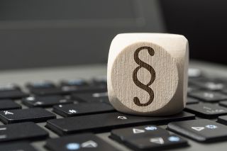 Foto: Würfel auf Tastatur mit Paragraph